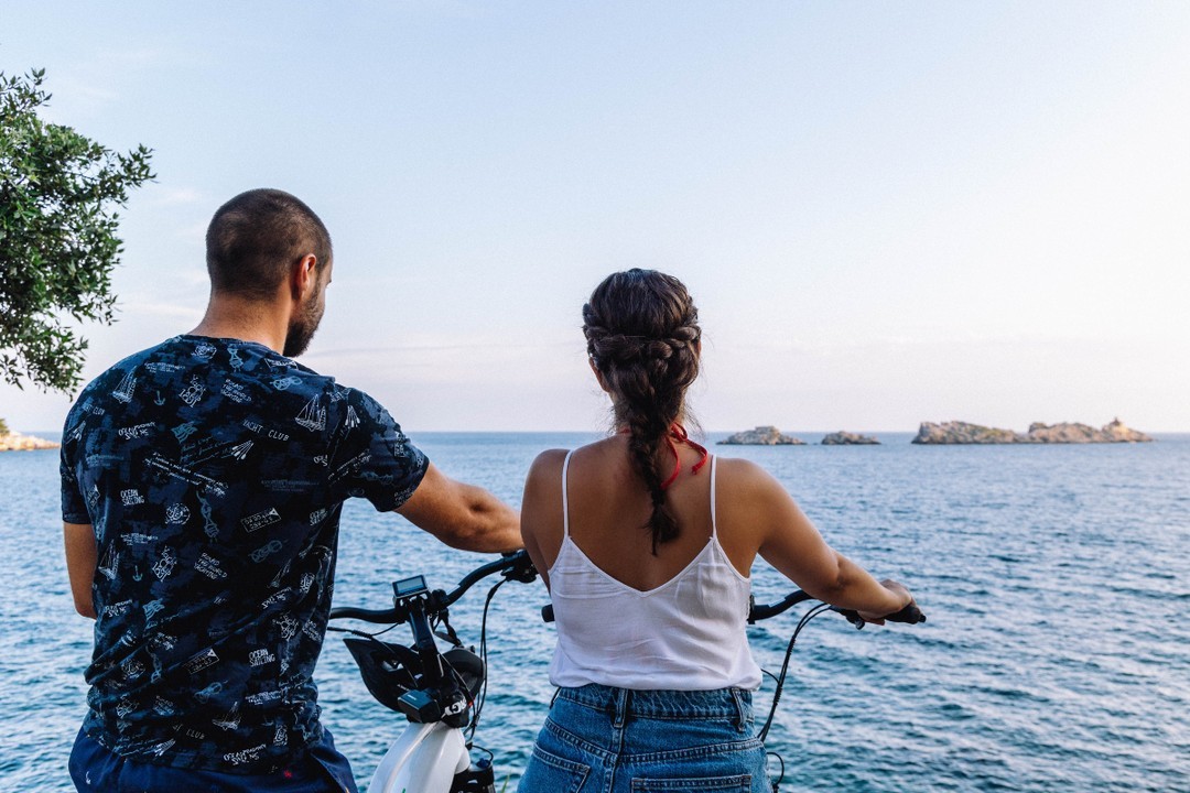 A couple on e-bikes looking out over the Adriatic Sea near Dubrovnik